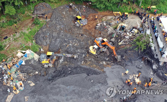 (부산=연합뉴스) 태풍 미탁이 한반도를 관통한 3일 부산 사하구 산사태 사고 현장에서 119구조대와 중장비 등이 토사를 걷어내고 있다. 사고 순간 토사가 식당, 공장 건물 3곳을 덮쳐 주민 4명이 매몰된 것으로 추정된다. 2019.10.3