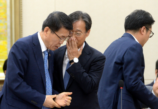 은성수(왼쪽) 금융위원장이 4일 오전 국회에서 열린 국회 정무위원회 국정감사에 출석, 유동수(가운데) 더불어민주당 간사와 귀엣말을 나누고 있다.