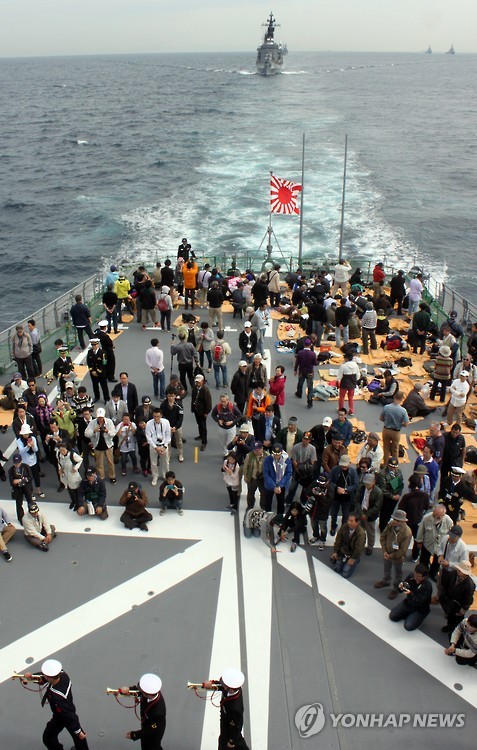 2015년 일본 가나가와(神奈川)현 앞 바다인 사가미(相模)만 해상의 일본 해상자위대 범용 호위함 ‘무라사메’에서 해상자위대원이 나팔을 부는 것을 탑승객이 지켜보고는 모습. [연합뉴스 자료사진]