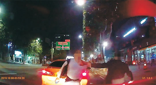 지난 8일 새벽 서울 서초구 서초동의 한 도로에서 술에 취한 법원행정처 서기관 A 씨가 택시기사 최모 씨의 멱살을 잡아 끌면서 폭행을 가하고 있다.    YTN 제공