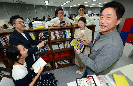 서영택(오른쪽) 밀리의 서재 대표이사와 임직원들이 지난 10일 서울 마포구 상암동 본사에서 새로 내놓을 서비스에 대해 담소를 나누고 있다. 신창섭 기자