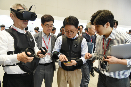지난달 25일 LG사이언스파크에서 열린 ‘LG 스타트업 테크페어’에서 안승권(오른쪽 두 번째) LG사이언스파크 대표, 박일평(〃 세 번째) LG전자 최고기술책임자(CTO) 등이 ‘비햅틱스’의 제품을 체험하고 있다.   LG 제공