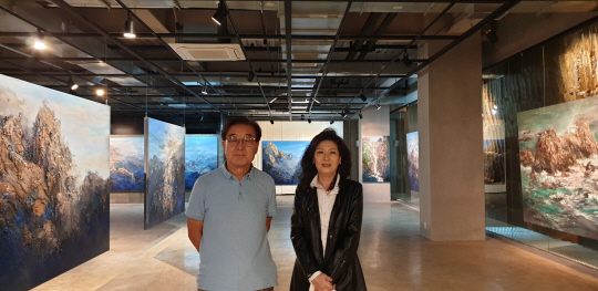 김주원(왼쪽) 석파랑 대표와 개관전 주인공 김인순 작가가 작품을 배경으로 포즈를 취했다. ‘석파랑 아트홀’은 암벽을 뚫고 만들어졌으며 전시된 작품 뒤편에 깎아낸 암벽 흔적이 보인다.