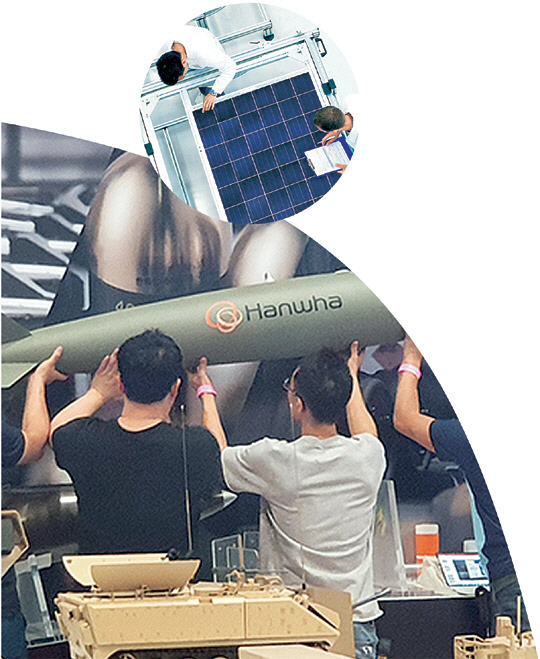 한화큐셀 연구원들이 태양광 제조 개발업무를 수행하고 있다. 한화큐셀 제공(작은 사진) ▼ ㈜한화·한화디펜스·한화시스템이 지난 14일 미국에서 열린 방산 전시회에서 유도미사일 모형을 설치하고 있다. 한화그룹 제공