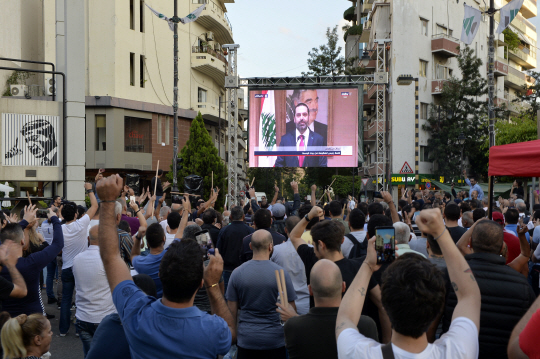 29일 레바논 베이루트에서 거리로 나온 반정부 시위대가 사드 하리리 총리의 사퇴 발표 방송을 보며 환호하고 있다. EPA 연합뉴스