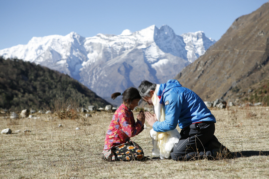 엄홍길 대장이 엄홍길휴먼재단을 통해 지난 2010년 네팔 4060m 고산지대 ‘팡보체’에 건립한 첫 휴먼스쿨의 학생과 마주 앉아 인사하고 있다.  엄홍길휴먼재단 제공