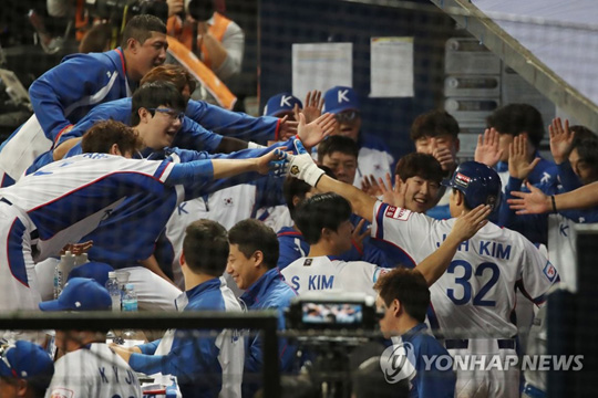 (서울=연합뉴스) 8일 오후 서울 구로구 고척스카이돔에서 열린 2019 WBSC 프리미어12 예선라운드 C조 한국과 쿠바의 경기. 5회 말 2사 2루에서 한국 김재환이 김현수의 1타점 적시타 때 홈인한 뒤 더그아웃으로 들어와 동료들과 하이파이브하고 있다. 2019.11.8