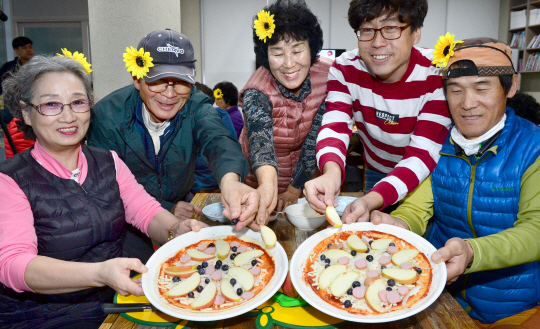 빙기실마을을 찾은 사람들이 수확한 사과로 피자 토핑을 하고 있다.