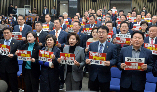 나경원(앞줄 오른쪽 세 번째) 원내대표 등 자유한국당 지도부와 의원들이 27일 오전 국회에서 열린 의원총회에서 이날 국회 본회의에 부의된 공직선거법 개정안 등의 처리에 반대하는 내용의 손팻말을 들고 구호를 외치고 있다.  김낙중 기자