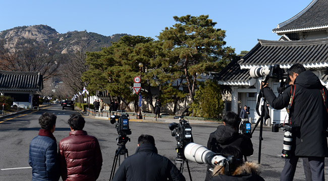 검찰이 청와대 압수수색에 나선 4일 오전 춘추관 출입구에서 기자들이 여민관 쪽을 바라보며 검찰의 압수수색 물품 반출을 기다리고 있다. 곽성호 기자