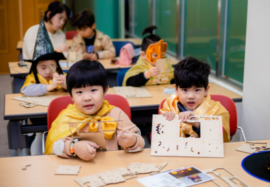 핼러윈데이 복장을 한 아이들이 반송종합사회복지관에서 골판지를 이용한 공작 놀이를 하고 있다.