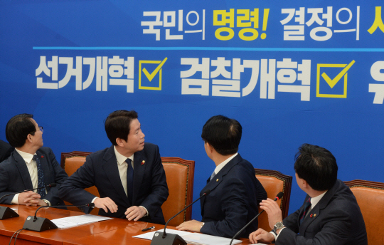 이인영(왼쪽 두 번째) 더불어민주당 원내대표와 조정식(〃 세 번째) 정책위의장 등이 12일 오전 국회에서 열린 정책조정회의에서 공직선거법 개정안과 검찰 개혁 법안의 조속한 처리를 강조하는 내용의 배경막을 쳐다보고 있다. 김선규 기자