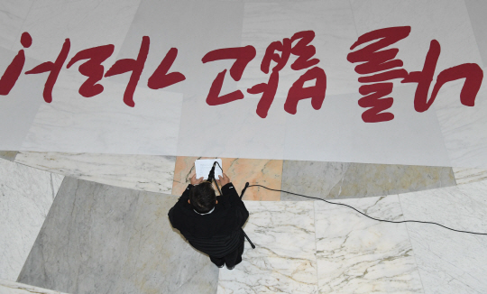 황교안 자유한국당 대표가 12일 오전 국회 본관 로텐더홀에서 열린 최고위원회의에서 모두발언을 하고 있다. 황 대표 앞쪽 바닥에 ‘나를 밟고 가라!’라는 글귀가 쓰인 대형 천이 펼쳐져 있다. 황 대표는 지난 10일 더불어민주당 등의 내년도 정부 예산안 강행 처리에 반발, 로텐더홀에서 무기한 농성을 벌이고 있다.