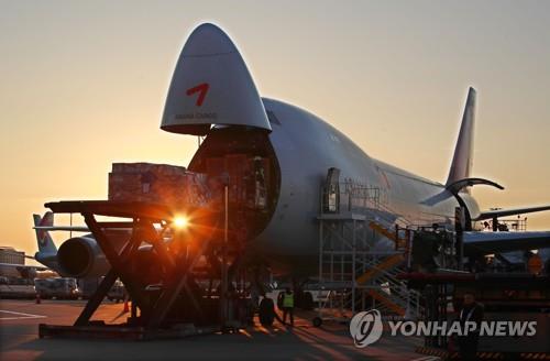‘수출 강국’인 대한민국은 멈출 수 없다. 정부는 2020년 글로벌 수출 6위 위상을 이어갈 수 있도록 수출금융 규모를 23조5천억원 늘리고, 수출 바우처 지원 기업 수도 3천500곳으로 확대하는 등 총력 지원에 나선다. 항공 화물 적재로 분주한 인천국제공항 아시아나항공 화물터미널 너머로 해가 떠오르고 있다. [연합뉴스 자료사진]