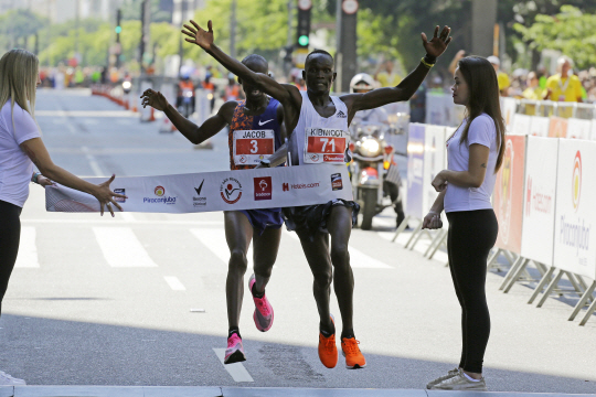 케냐의 키비왓 칸디(오른쪽)가 1일(한국시간) 브라질 상파울루에서 열린 제95회 산 실베스트르 데 상파울루 남자육상 15㎞에서 우간다의 제이컵 키플리모를 간발의 차이로 제치며 결승선을 통과하고 있다.  AP연합뉴스