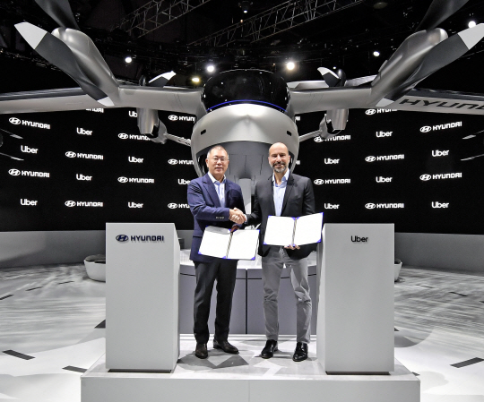 정의선(왼쪽) 현대자동차그룹 수석부회장이 7일(현지시간) 미국 라스베이거스 컨벤션센터 노스 홀 현대차 전시관에서 다라 코스로샤히 우버 CEO와 ‘도심 항공 모빌리티(UAM) 사업 추진을 위한 협력’ 계약을 체결하고 있다.   현대자동차 제공
