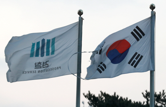 법무부가 윤석열 검찰총장 참모진을 완전히 해체하는 수준의 검사장급 인사를 단행한 지 하루 뒤인 9일 오전 서울 서초구 서울중앙지검 앞 국기게양대에 강풍에 찢어진 태극기와 검찰기가 펄럭이고 있다. 낡은 태극기·검찰기는 이날 새것으로 교체됐다. 뉴시스
