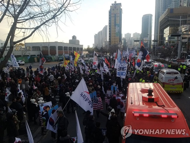 (부산=연합뉴스) 18일 오후 부산 동구 중앙대로 부산진역 앞 도로에서 태극기 집회 참가자 7명이 거리행진 중 차량에 치여 다치는 사고가 발생했다. 시위대가 현장을 둘러싸고 있는 가운데 119구조대가 출동, 현장을 수습하고 있다. 2020.1.18 [부산소방본부 제공]
