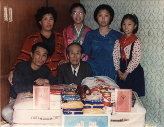 고 황영준 화백의 재북 가족. 수양아들 황금철과 며느리 그리고 세 명의 손녀가 2002년 이산가족 상봉을 앞두고 남측 가족에게 줄 선물을 앞에 두고 사진을 찍은 것으로 보인다.  소장자 제공