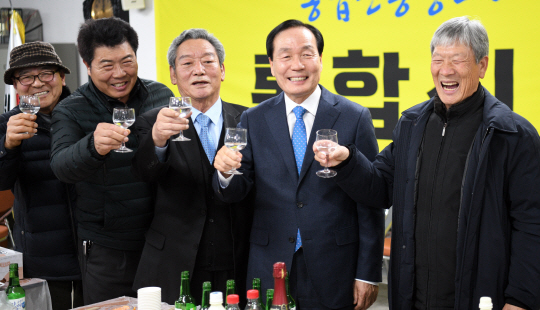 김주수(오른쪽 두 번째) 의성군수가 22일 오전 경북 의성군 ‘통합신공항의성군유치위원회’ 사무실에서 군위군 소보면·의성군 비안면 지역이 대구·경북 통합 신공항 공동 후보지로 확정 발표된 후 주민들과 함께 건배하며 자축하고 있다.  ●