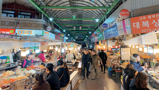 설 연휴를 사흘 앞둔 21일 저녁, 서울 종로구 광장시장을 찾은 시민들이 음식을 먹고 있다.