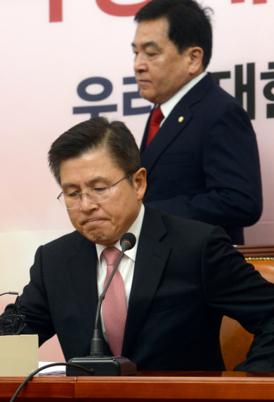 황교안(앞) 자유한국당 대표가 30일 오전 국회에서 열린 최고위원회의에 참석하기 위해 입을 굳게 다문 채 자리에 앉고 있다. 뒤는 심재철 원내대표.