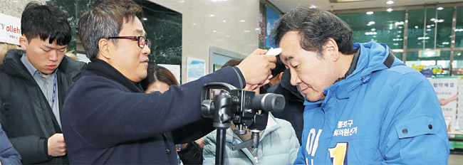 더불어민주당 소속으로 21대 국회의원 총선거 서울 종로 선거구 출마를 선언한 이낙연(오른쪽) 전 국무총리가 10일 오전 종로구민회관을 찾아 지역 주민과 만나기 전 신종 코로나바이러스 감염증(우한 폐렴) 감염 여부를 확인하기 위해 이마에 측정기를 대고 체온을 재고 있다. 연합뉴스