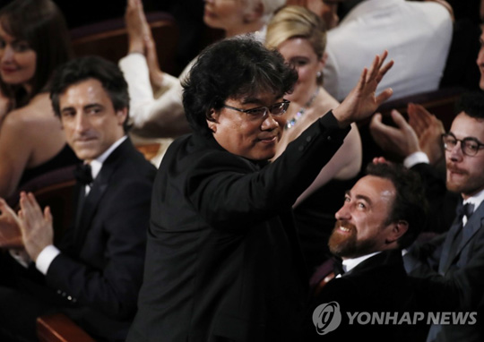 (할리우드 EPA=연합뉴스) 봉준호 감독이 9일(현지시간) 미국 캘리포니아 주 할리우드 돌비 극장에서 열린 제92회 아카데미 시상식에서 영화 ‘기생충’이 각본상 수상작으로 호명되자 일어서고 있다.