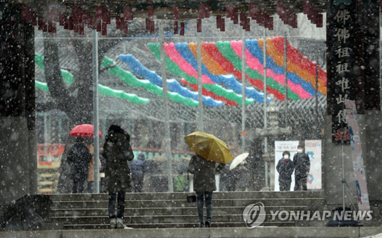 (서울=연합뉴스) 눈이 내린 16일 서울 종로구 조계사로 시민들이 출입하고 있다. 2020.2.16