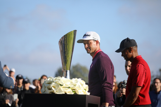 호주의 애덤 스콧(왼쪽)이 17일 오전(한국시간) 미국 캘리포니아주 퍼시픽 팰리세이즈의 리비에라 컨트리클럽에서 PGA투어 제네시스인비테이셔널 정상에 오른 뒤 트로피를 바라보고 있다. 최하위에 그친 미국의 타이거 우즈는 고개를 숙이고 트로피를 외면하면서 스콧의 뒤를 따르고 있다. EPA 연합뉴스