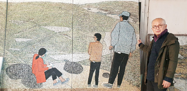 박성남 화백이 500호짜리 대작 ‘계승-징검돌과 예배당이 보이는 풍경’(혼합재료, 488×173㎝, 2020) 앞에서 작품에 대해 설명하고 있다. 그림 안 오른쪽에 지팡이를 짚고 풍경을 감상하는 사람이 아버지 박수근이고, 그 옆의 소년이 박 화백 본인이다.