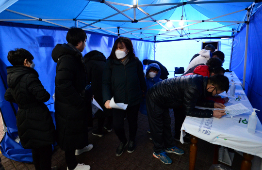 19일 오전 불특정 감염원에 의한 지역사회 감염으로 보이는 신종 코로나바이러스 감염증(COVID-19) 확진자가 발생한 서울 성동구 한양대병원에서 외래환자들이 문진표를 작성하고 있다.