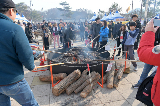 올해 1월 열린 2020 겨울공주 군밤축제에 참여한 관광객들이 대형 화로에서 밤을 굽고 있다. 공주시청 제공