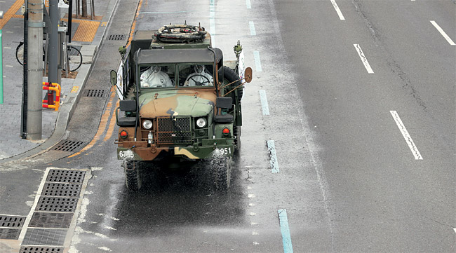 육군 50사단 소속의 화학전 전용 제독차량이 27일 오전 신종 코로나바이러스 감염증 확진자가 폭증하는 대구의 남구 대명동 일대 거리에 소독약을 살포하고 있다.  연합뉴스