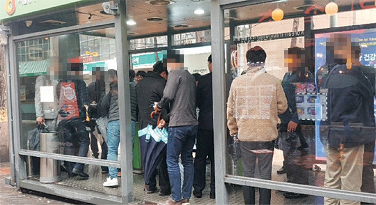 지난 25일 서울 중구 명동에 있는 한 흡연 부스 안이 마스크를 쓰지 않은 흡연자들로 빼곡하다.