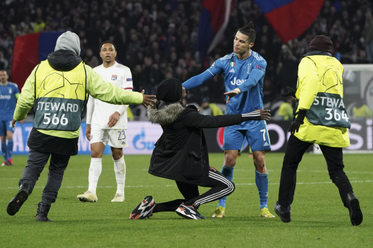 유벤투스의 크리스티아누 호날두가 27일 오전(한국시간) 프랑스 데신샤르피외의 파르크 올랭피크 리오네에서 열린 올랭피크 리옹과의 UEFA 챔피언스리그 16강 1차전에서 경기장에 난입한 팬의 포옹 요청을 거부하고 있다. AP연합뉴스