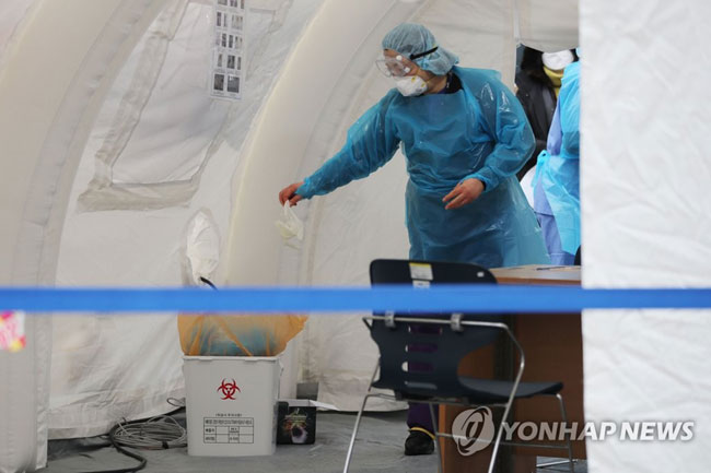 (서울=연합뉴스) 2월 28일 오후 신종 코로나바이러스 감염증(코로나19) 전담병원으로 전환된 서울 중랑구 서울의료원에 설치된 선별진료소에서 의료진이 장갑을 폐기물 용기에 버리고 있다. [연합뉴스 자료사진]