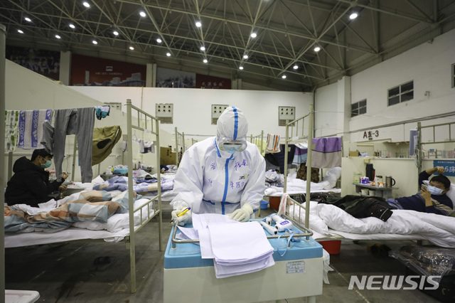 [우한=AP/뉴시스]2월18일(현지시간) 신종 코로나 바이러스 감염증(코로나19) 진원지인 중국 후베이성 우한시의 임시 병원 시설에서 의료진이 서류를 보고 있는 모습. 이곳은 전시관을 개조해 만들어졌다. 2020.03.02.