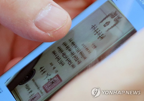 (서울=연합뉴스) 4일 오전 국회 법제사법위원회 전체회의에서 한 의원이 신천지예수교 증거장막성전(신천지)의 이만희 총회장의 국가유공자증서를 보고 있다.