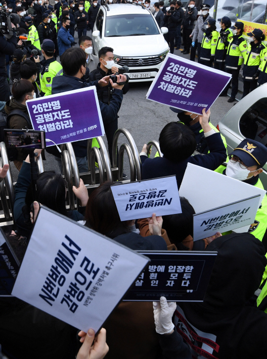 25일 오전 서울 종로구 종로경찰서 앞에 모인 시위대가 이날 검찰로 송치되는 텔레그램 ‘박사방’ 운영자 조주빈을 태운 차량 앞에 모여 조주빈이 유포한 성착취물을 이용한 사람도 처벌할 것을 요구하고 있다.