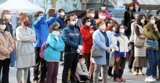 6일 경기 고양시 화정문화광장에서 시민들이 마스크를 착용한 채 21대 국회의원 총선거에 출마한 한 정당 후보자의 연설을 듣고 있다.