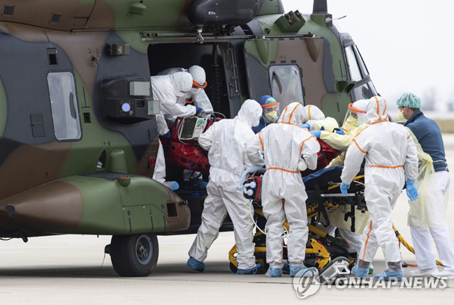 지난 4일 프랑스 동부 그랑데스트지방에서 코로나19 중증 환자가 독일 드레스덴공항으로 이송돼 의료진의 보살핌을 받고 있다. [AP=연합뉴스]