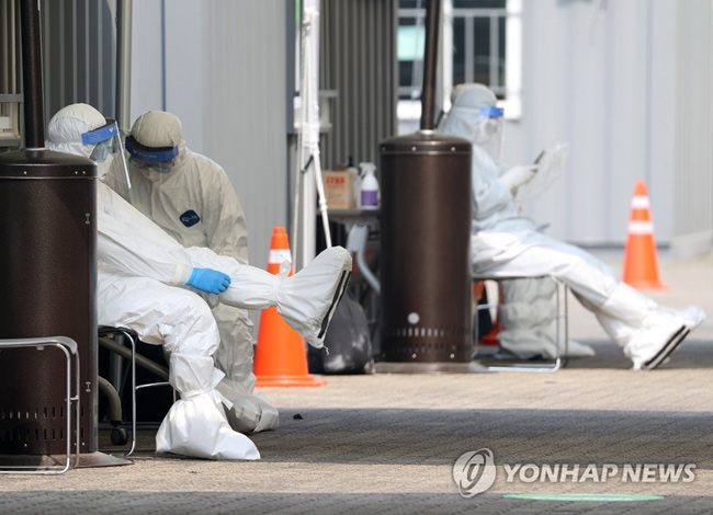 (서울=연합뉴스) 지난 7일 오전 서울 송파구 잠실종합운동장 주경기장에 설치된 신종 코로나바이러스(코로나19) 드라이브 스루 선별진료소에서 의료진이 방호복을 점검하고 있는 모습.