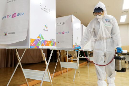 21대 국회의원 총선거 사전투표 개시를 하루 앞둔 9일 오전 서울 성동구 왕십리도선동 주민센터에 마련된 사전투표소에서 방역당국 관계자가 방역작업을 하고 있다.  뉴시스