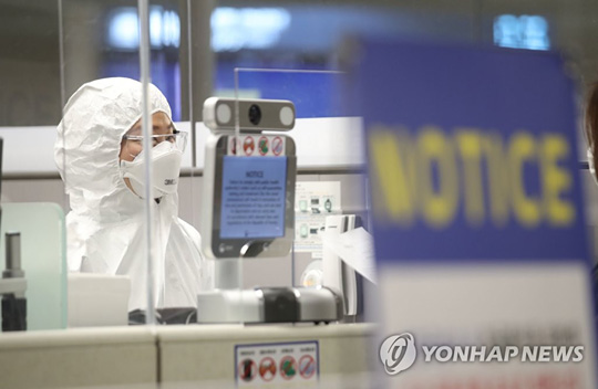 (영종도=연합뉴스)  인천공항 출입국 외국인청 입국심사관이 지난 8일 오후 인천국제공항 제2터미널 유증상자 전용 입국심사대에서 방진복을 입은 채 업무를 준비하고 있다.