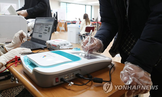 (울산=연합뉴스) 제21대 국회의원선거 사전투표 첫날인 10일 오전 울산시 남구 울산보훈지청에 마련된 옥동 사전투표소에서 유권자가 비닐장갑을 끼고 있다. 2020.4.10