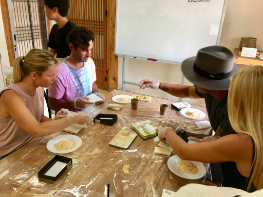 ‘북촌 한옥길 축제’에서 외국인 관광객들이 인절미 만들기 체험을 하고 있다.