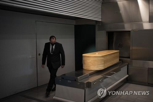 스페인의 한 장례식장에서 직원이 코로나19로 숨진 희생자의 관을 옮기고 있다. [AP=연합뉴스 자료사진]