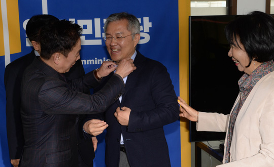 4·15 총선에서 열린민주당 비례대표로 국회의원에 당선된 최강욱(가운데) 전 청와대 공직기강비서관이 20일 오전 여의도 당사에서 열린 열린민주당 최고위원회에서 정봉주(왼쪽) 전 의원이 자신의 옷매무새를 바로잡아주자 웃음을 터트리고 있다.