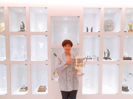 박세리 감독이 대전 자택 내 거실 장식장 앞에서 1998년 US여자오픈 우승 때 받은 트로피를 들고 포즈를 취하고 있다.  바즈인터내셔널 제공